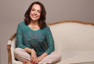 large photo of Mona Delahooke sitting on a sofa