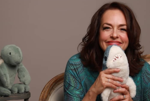 photo of Dr Mona Delahooke smiling holding a stuffed shark toy
